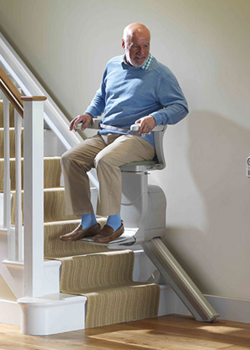 Man sitting in a stair lift in the home