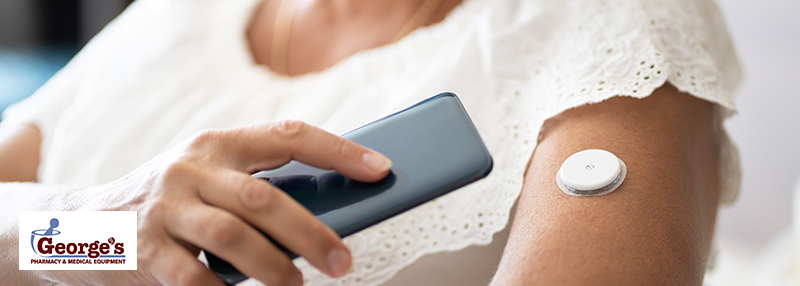 Woman holding phone close to a CGM attached to her arm