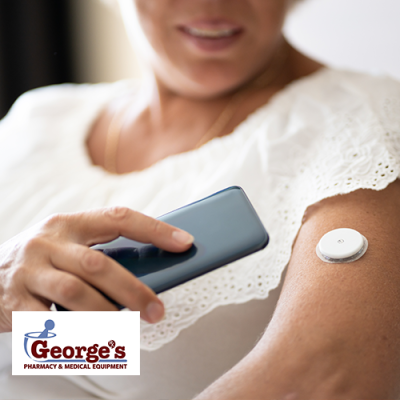 Woman holding phone close to a CGM attached to her arm